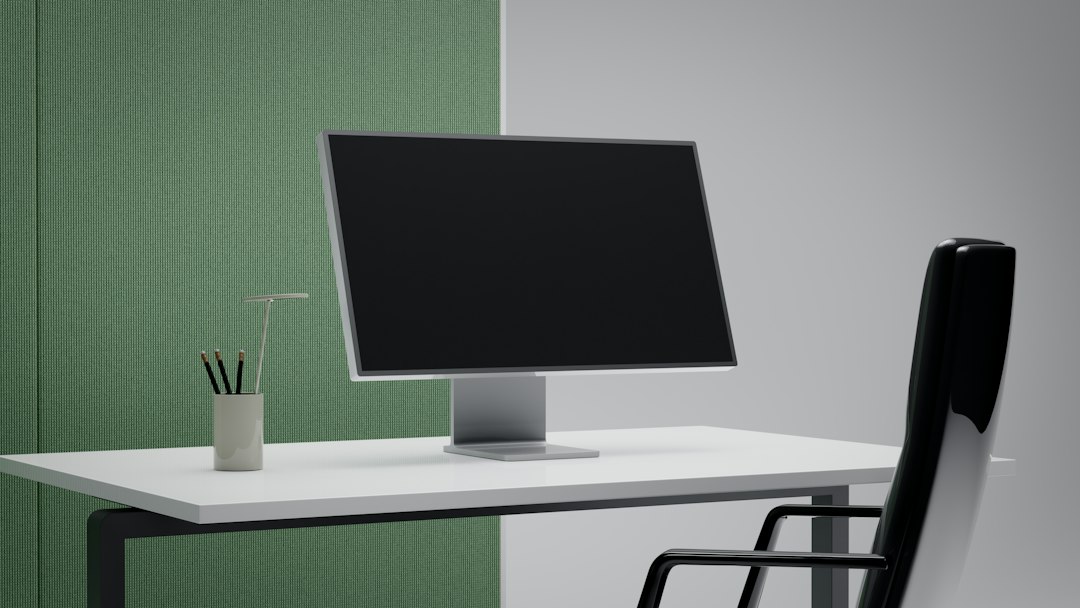 A modern office desk with a computer monitor and chair