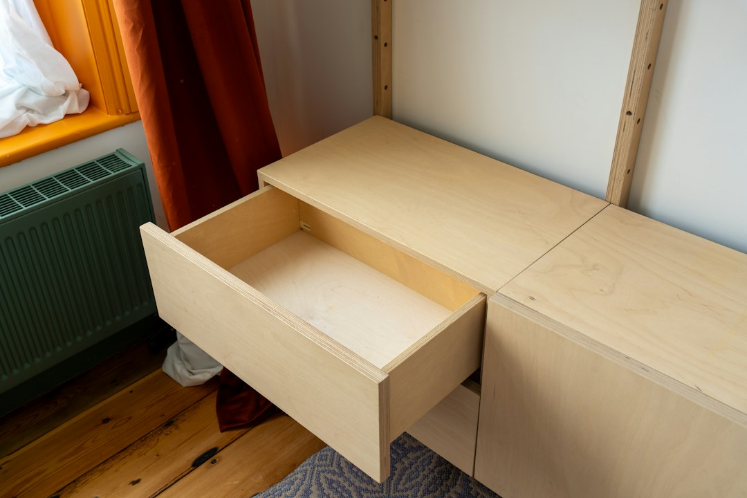 An open wooden drawer in a light wood cabinet